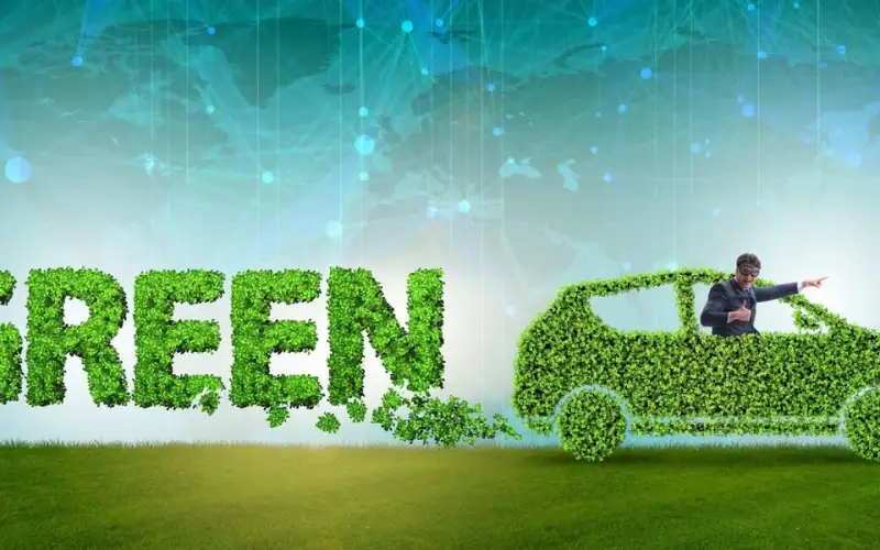 Illustration of a car made of green leaves on grass