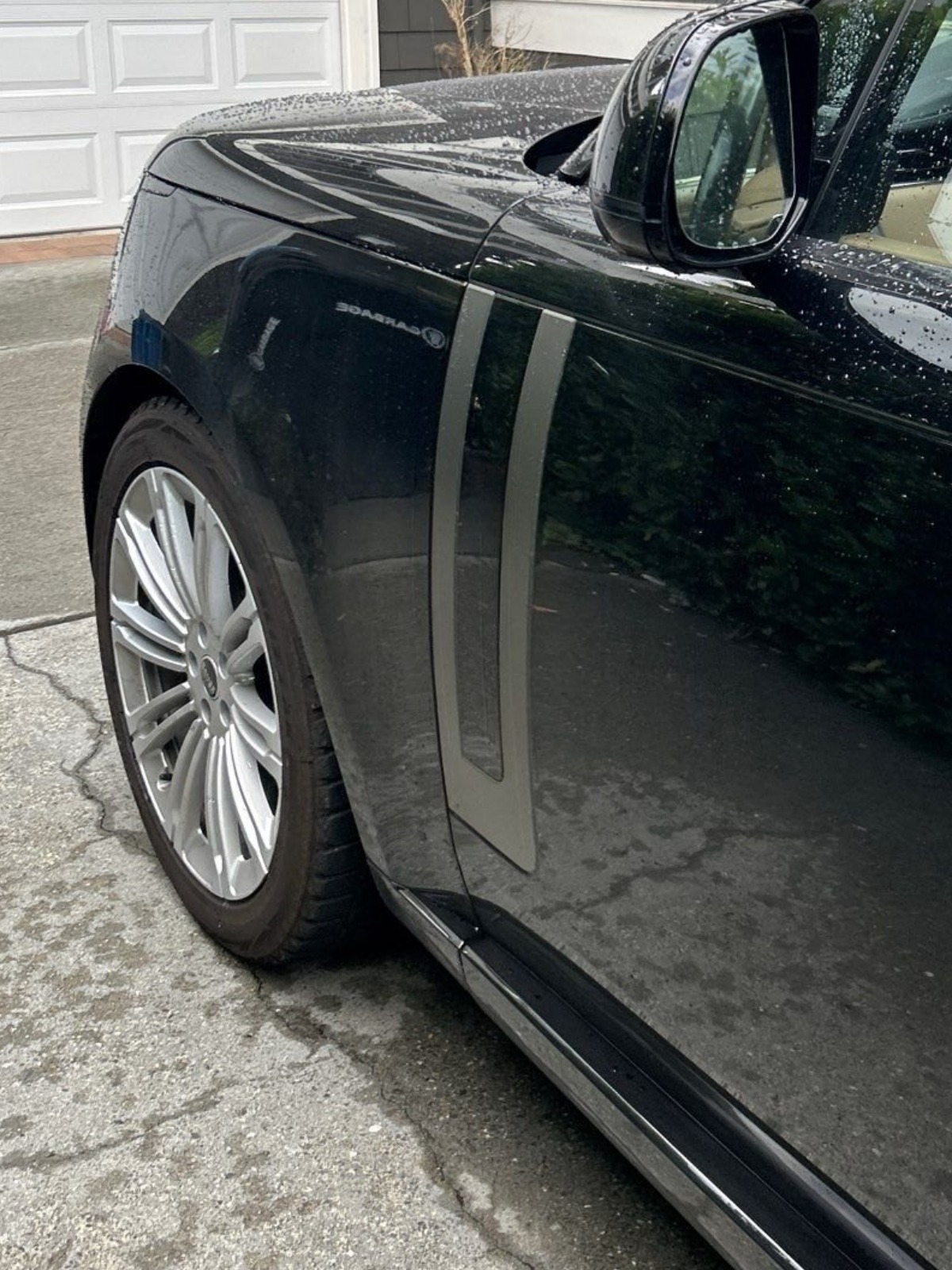 After: the same Range Rover front quarter panel and wheel washed, decontaminated and polished to a gloss