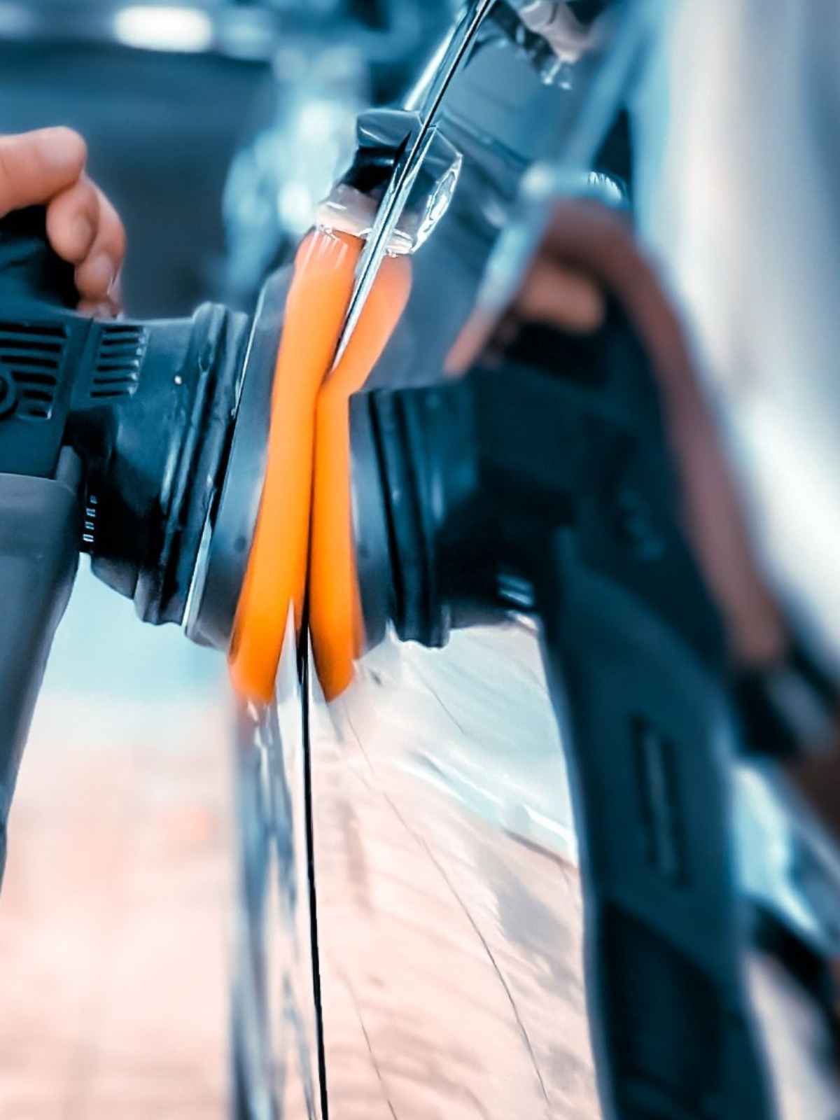 Technician machine polishing a vehicle panel to remove swirl marks